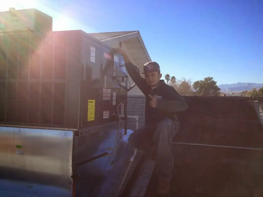 HVAC technician performing Air Duct Repair on a rooftop unit in Helena-West Helena